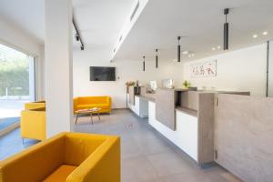 a living room with a yellow couch and a counter at Horizon Hotel Badesi in Badesi