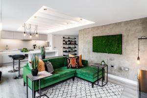 a living room with a green couch and a kitchen at Borough Market 2-Bed Apartments in London