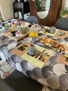 una mesa con un mantel con comida. en La Marokanette, en Saint-Maclou-de-Folleville