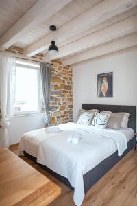 1 dormitorio con 1 cama grande y pared de ladrillo en GG art apartments II, en Piran