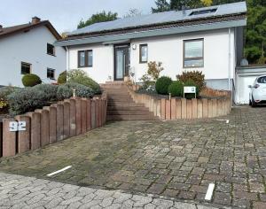 uma casa branca com uma cerca e uma entrada em Kleine Auszeit em Mendig