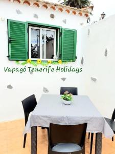 een tafel en stoelen met een witte tafel en groene ramen bij Rinconcito Rural con encanto en Las Hayas in Acardece