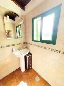 een badkamer met een wastafel en een spiegel bij Rinconcito Rural con encanto en Las Hayas in Acardece