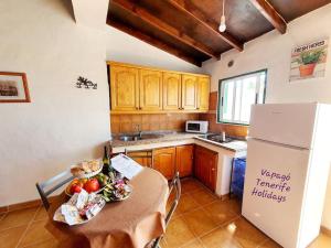 a kitchen with a table and a refrigerator at Rinconcito Rural con encanto en Las Hayas by Vapagó Tenerife in Acardece +14 photos