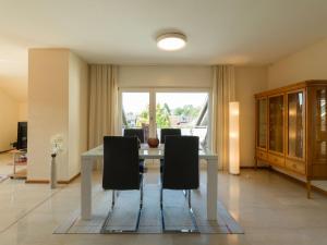 a dining room with a white table and chairs at Ferienwohnung Lohrig in Weiskirchen