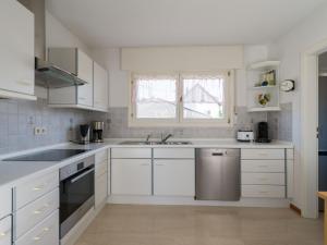 a kitchen with white cabinets and a sink and a window at Ferienwohnung Lohrig in Weiskirchen