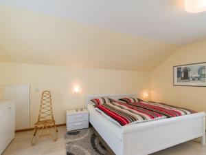 ein Schlafzimmer mit einem weißen Bett und einer Leiter in der Unterkunft Ferienwohnung Lohrig in Weiskirchen