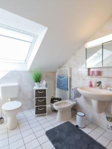 ein Badezimmer mit einem Waschbecken, einem WC und einem Waschbecken in der Unterkunft Ferienwohnung Lohrig in Weiskirchen