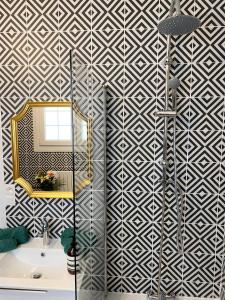 La salle de bains est pourvue d'une douche avec un miroir et un lavabo. dans l'établissement Villa Opale Etretat, à Étretat