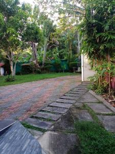 a cobblestone walkway in a yard next to a house at Relaxing apartment l Revenla garden l in Matara