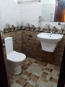 uma casa de banho com um WC branco e um lavatório. em Relaxing apartment l Revenla garden l em Matara