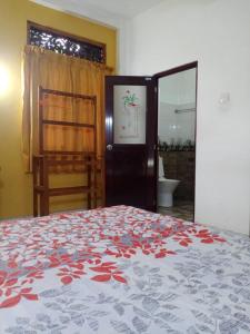a bedroom with a bed with a red and white bedspread at Relaxing apartment l Revenla garden l in Matara