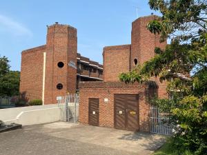 a brick building with two garage doors on it at See Uitsig 2 in Uvongo Beach