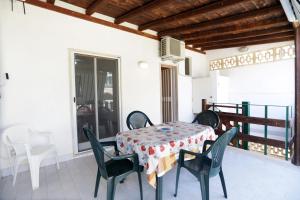 ein Esszimmer mit Tisch und Stühlen auf einem Balkon in der Unterkunft Ulisse apartment on the sea in Punta Secca