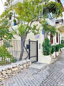 a tree in front of a building with a gate at Marthas DeLight Rooms in Chania Town