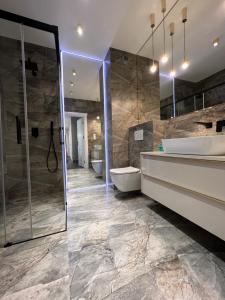 La salle de bains est pourvue de 2 lavabos, d'une baignoire et d'une douche. dans l'établissement Apartament Primavera 3 MINI SPA Komfort dla grup biznesowych , rodzin ,osób indywidualnych, à Kielce