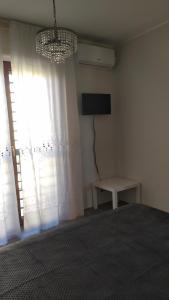 - une chambre avec un lit, une télévision et une fenêtre dans l'établissement B&B Walter & Chiara, à Altamura