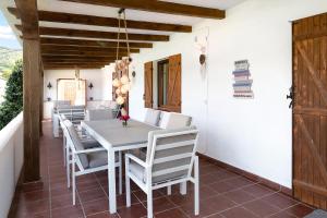 a dining room with a white table and chairs at Villalaluna lacasa in Vejer de la Frontera