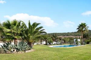 um quintal com piscina e palmeiras em Villalaluna lacasa em Vejer de la Frontera