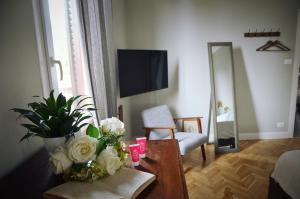 un soggiorno con tavolo e fiori di Charming Flat Milazzo 32 a Bologna