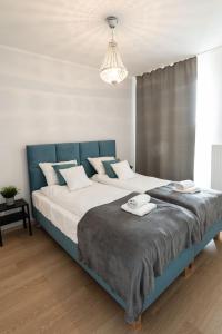 a bedroom with a large bed with a blue headboard at Sołtysowska Apartment in Krakow