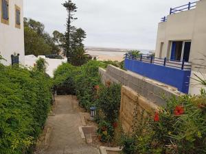 a path next to a building and a beach at sultana duplex 3 pour les familles in Oualidia