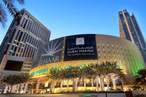 a building in a city with palm trees in front of it at Royal Manor - Dream Tower in Dubai