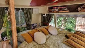 a bedroom with a bed with pillows and a mirror at AirstreamNB in Schayk