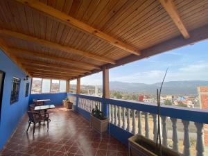 a balcony with a wooden roof with a table and chairs at Casa Abdou in Chefchaouen