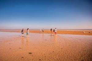 a group of people walking on the beach at Le Phare in Les Portes