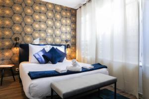 a bedroom with a bed with blue pillows at N1 Des Études Cosy Duplex Netflix Balcon ConciergerieDameCarcas in Carcassonne