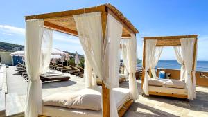 two beds on a patio with the ocean in the background at Arabela 2 Apartments in Utjeha