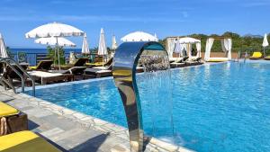 a swimming pool with a fountain in the middle at Arabela 2 Apartments in Utjeha