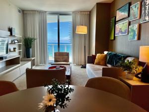 uma sala de estar com um sofá e uma mesa em Modern Beachfront Condo with Stunning Ocean View em Hollywood