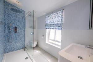 a bathroom with a shower and a toilet and a sink at The Pink House in Southwold - Air Manage Suffolk in Southwold