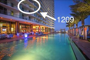 ein Hotel mit einem Pool vor einem Gebäude in der Unterkunft Modern Beachfront Condo with Stunning Ocean View in Hollywood