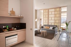 a kitchen and living room with a couch and a table at Eric Vökel Boutique Apartments - Amsterdam Suites in Amsterdam