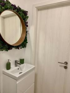 uma casa de banho com um lavatório e um espelho na parede em Sicomoro Casa em Sopron