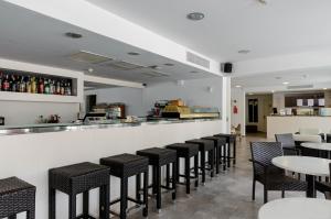 un bar con mesas y sillas negras en un restaurante en Hostal Gami Adults Only, en Cala Ratjada