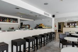 bar z czarnymi krzesłami i stołami w restauracji w obiekcie Hotel Gami Adults Only w Cala Ratjada