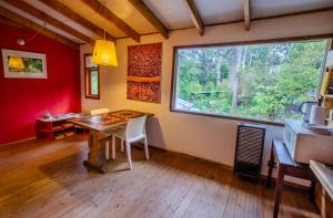 uma sala de jantar com uma mesa e uma grande janela em la casa del sol em San Carlos de Bariloche