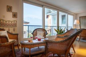 ein Wohnzimmer mit Korbstühlen und einem Tisch mit Getränken in der Unterkunft Hotel Romanda in Levico Terme