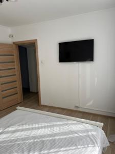 a bedroom with a bed and a flat screen tv on a wall at Star Apartments in Baia Mare