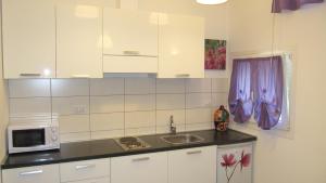 a kitchen with a sink and a microwave at Casetta Romantica Viola Lerici in Lerici