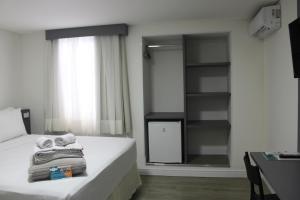 1 dormitorio con cama con espejo y escritorio en Sagres Praia Hotel en Balneario Camboriú