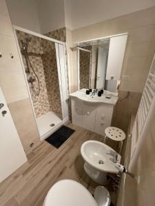 a bathroom with a toilet and a sink and a shower at La Corte Residence in Fabriano