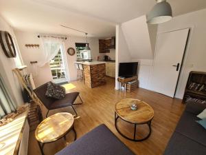 a living room with a couch and tables and a kitchen at Have a nice stay! - North Sea Home in Noordwijk aan Zee