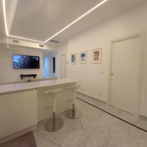 Dieses weiße Zimmer verfügt über eine Theke und einen TV an der Wand. in der Unterkunft Villetta Gramsci, Alassio in Alassio