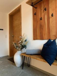 a vase sitting on a wooden bench next to a door at Loft über dem Bodensee in Heiligenberg