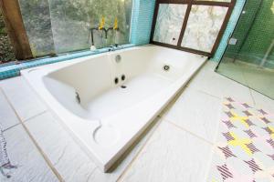 baño con bañera blanca y ventana en Suítes Casa Grande, en Abraão
